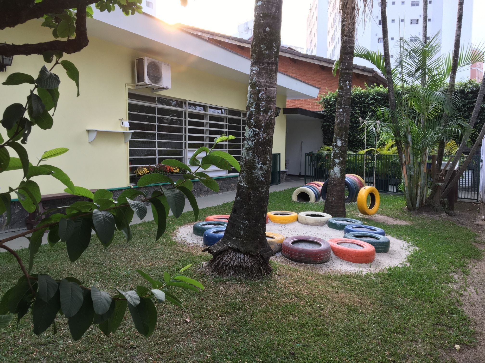Parquinho no jardim gramado, tanque de areia e horta